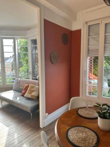 uma sala de estar com um sofá e uma mesa em Appartement lumineux et spacieux em Charleville-Mézières
