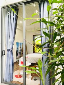 a room with a bed and a window with plants at HOMEY Homestay Hue 