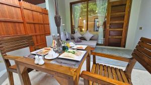 a dining room with a table and chairs and a couch at Dhonfalhu Dhigurah in Dhigurah