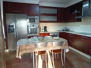a kitchen with a marble table and two chairs at Casa/chalet en Sanxenxo 3hab. in Sanxenxo