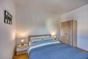 a bedroom with a blue bed and two night stands at Apartment Anita in Gedići