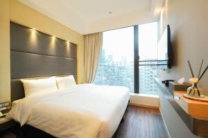a bedroom with a large bed and a large window at 盛世酒店 Epoch Hotel in Hong Kong