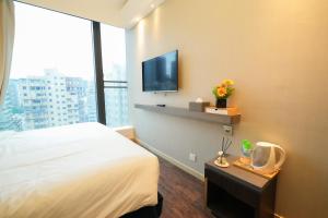 a hotel room with a bed and a flat screen tv at Epoch Hotel in Hong Kong