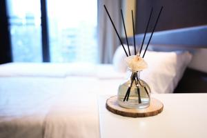 a vase with sticks in it sitting on a bed at Epoch Hotel in Hong Kong