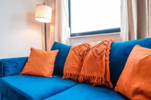 a blue couch with orange pillows on it at Carr St Ipswich in Ipswich