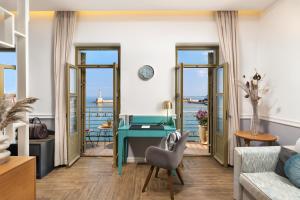 a living room with a desk and a view of the ocean at Elia Palatino Hotel in Chania