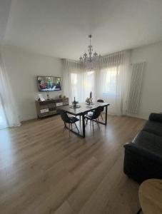 een woonkamer met een tafel en stoelen en een bank bij Ca’ Uccelli-Stupendo Appartamento 5 min da Venezia in Marghera
