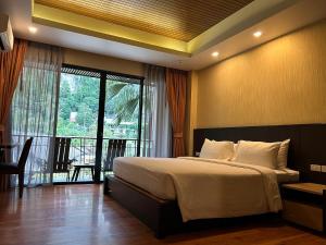 a bedroom with a large bed and a balcony at Aonang Hill Krabi-SHA Extra Plus in Ao Nang Beach