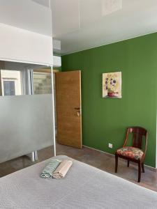 a bedroom with green walls and a bed and a chair at Casa S’Arraval in Mahón