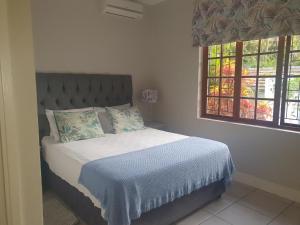 a bedroom with a bed and a window at Northlands Manor in Durban
