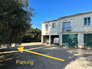a yellow arrow pointing to a house with a parking lot at La maison lumineuse de Bernis in Bernis