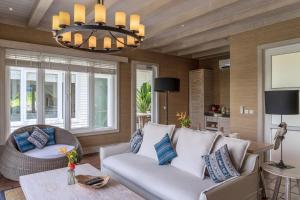 uma sala de estar com um sofá e um lustre em Lembeh Resort em Bitung