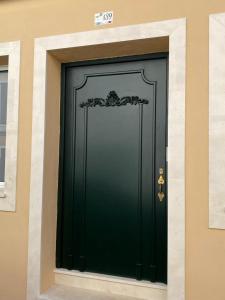 a green door on a building with a sign above it at Casa S’Arraval in Mahón
