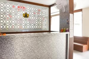 a kitchen with a glass partition with a patterned wall at Collection O 78427 Hotel Raj Regent in Somarda Kauasot