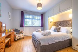 a bedroom with a large bed and a desk at Port Tara Holiday Home in Portballintrae