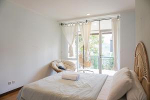 a bedroom with a bed and a large window at Over Easy Apartment in Bandung