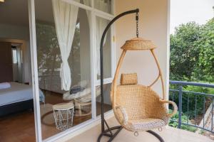 a porch with a swinging chair and a bed at Over Easy Apartment in Bandung