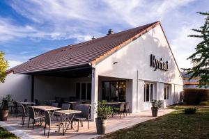 a restaurant with tables and chairs on a patio at Kyriad Villeneuve Saint Georges - Hôtel rénové in Villeneuve-Saint-Georges