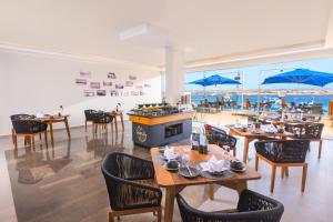 Naama Bay Suites & SPA في شرم الشيخ: مطعم به طاولات وكراسي ومطل على المحيط