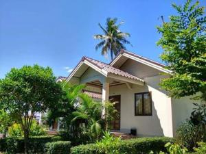 a small white house with a palm tree behind it at MSD House in Ko Por