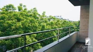 balcone con vista sugli alberi di Qotel B&B Hotel Rajouri Garden Above Ritu Marbel Near Rajouri Garden Metro Station a Nuova Delhi