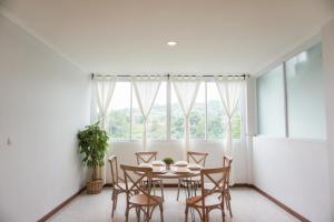 een eetkamer met een tafel en stoelen en een raam bij Over Easy Apartment in Bandung