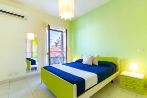 una camera con letto e pareti blu e verdi di Appartamento Minerva int6 - MyHo Casa a Tortoreto