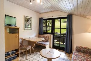 a living room with a table and chairs and a television at Villa Valluga in Mittelberg