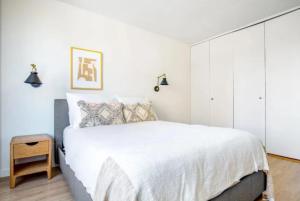 a bedroom with a white bed and a white closet at Relaxing 3BR Apartment in New York