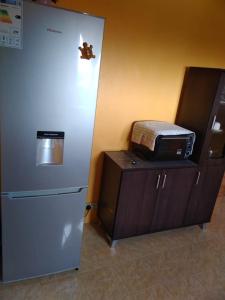 a refrigerator next to a counter with a microwave at Hibiscus chez Arielle in Rodrigues Island +4 photos