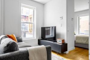 uma sala de estar com um sofá e uma televisão de ecrã plano em Relaxing 3BR Apartment em Nova Iorque
