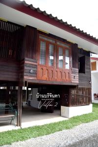 a wooden building with a bench in front of it at V2-Baan Borijinda-Lanna House in The old city of Chiang Mai in Chiang Mai