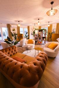 a living room with a large brown leather couch at Kyriad Villeneuve Saint Georges - Hôtel rénové in Villeneuve-Saint-Georges