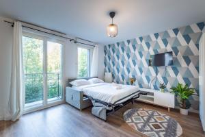 a bedroom with a bed and a large window at Blue Pearl By Plaza in Montévrain