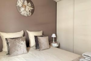 een slaapkamer met een bed met een klok aan de muur bij Cosy Bohème Parking, RDC, Loggia, Wifi in Libourne