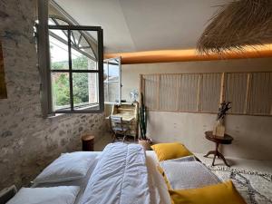1 dormitorio con 2 camas y ventana en Loft la Traversière, en Saint-Hippolyte-du-Fort