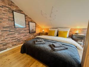 een slaapkamer met een bed en een bakstenen muur bij Cozy Apartment near city center Dresden by R&L in Dresden +6 foto's