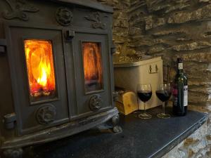 a stove with two glasses of wine and a bottle of wine at Seaside Georgian gem in Combe Martin