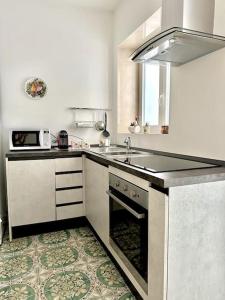 a kitchen with a sink and a stove top oven at La casa di Nonna Celeste in Brindisi