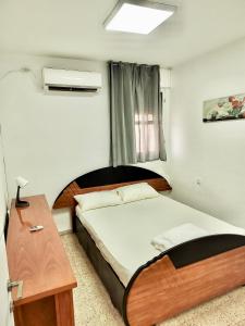 Dormitorio pequeño con cama y mesa en Уютная квартира в Кирьят-ям, en Qiryat Yam