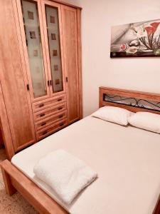 1 dormitorio con 1 cama y armario de madera en Уютная квартира в Кирьят-ям, en Qiryat Yam