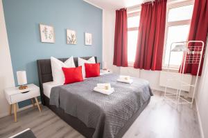 a bedroom with a bed with red pillows at Loh9 - Das Apartment im Citycenter - Parkplatz - Wlan - Aufzug in Chemnitz