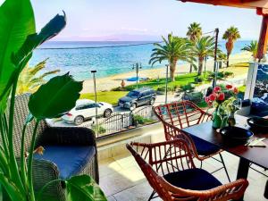 balkon ze stołem i krzesłami oraz widokiem na ocean w obiekcie Lux Suite Sea Front Avra w mieście Pefkochori