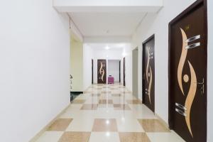 a corridor in a building with white walls and a tile floor at Flagship Flagship Hotel Dream Inn in Dānāpur