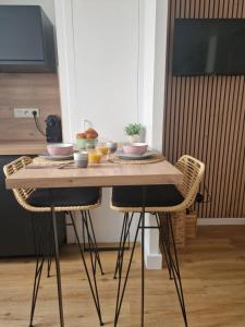 坎佩尔Le Cottage的一张木桌,两把椅子,上面有食物