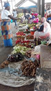 a group of people at a market with vegetables at flowerhouse Sukuta Gambia in Sukuta