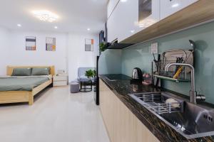 a kitchen with a sink and a bed in a room at 9 LIGHT APARTMENT in Hanoi