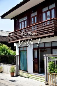 a building with a sign on the front of it at V1-Baan Borijinda-Wooden House in The old city of Chiang Mai in Chiang Mai