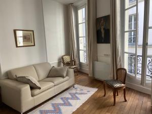 a living room with a couch and two chairs at Aux Terrasses de la Lune in Paris