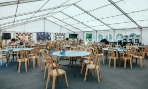 a group of tables and chairs in a tent at IOMTT Village at Isle of Man TT in Douglas